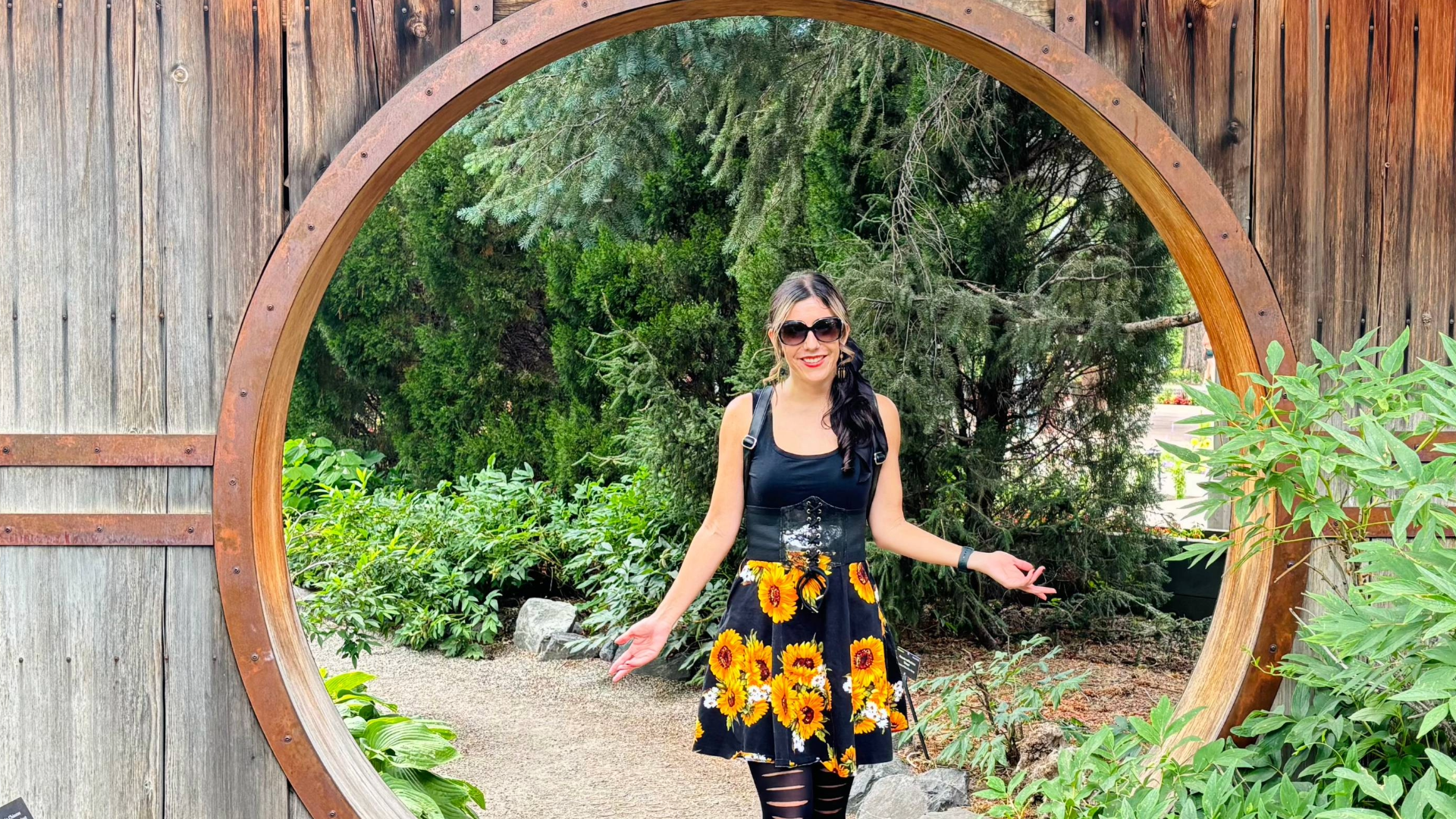 Crystal Mikolaijczak standing at a wooden garden gateway