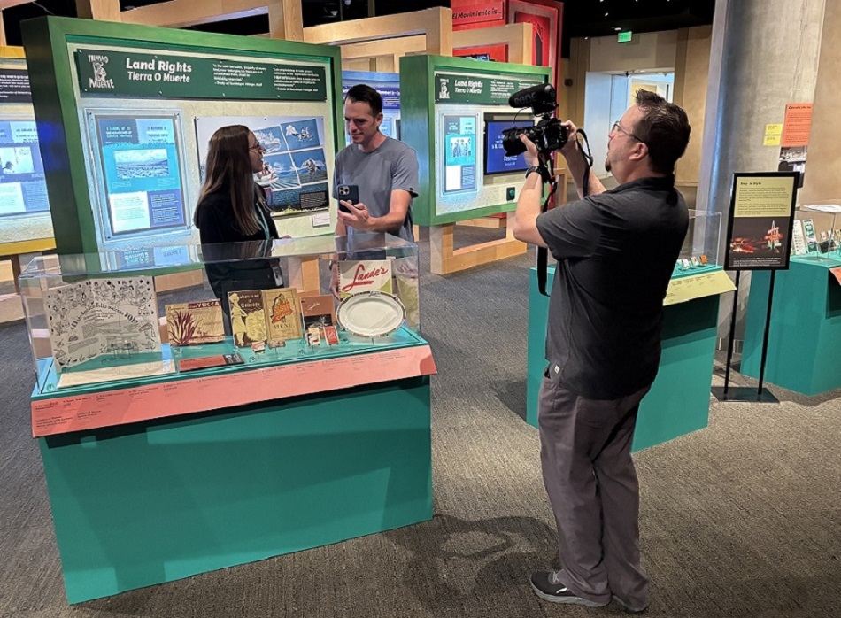 a videographer films a man using Aira ASL in the History Colorado museum